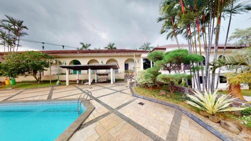a house with a swimming pool and palm trees at Ole Suite Hotel in Bogor