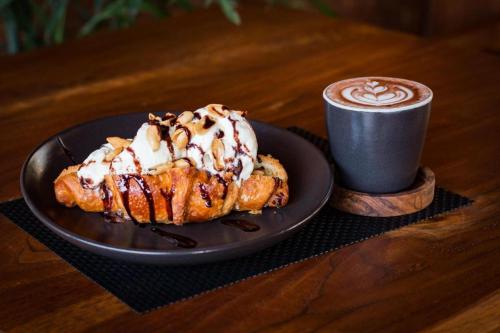 a plate with a pastry and a cup of coffee at Hadi Poetra Hotel in Kuta