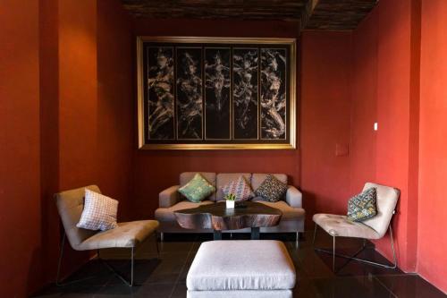 a living room with a couch and a table and chairs at Hadi Poetra Hotel in Kuta
