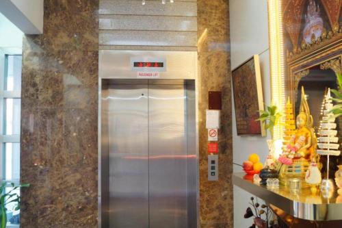 a large metal elevator in a room with a counter at BudgetOne Hotel in Singapore