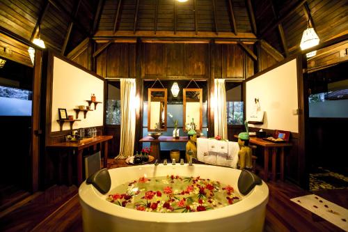 a large bath tub filled with flowers in a room at Villa Inle Boutique Resort in Nyaung Shwe
