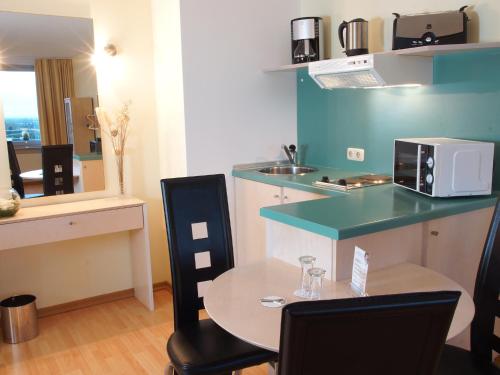 a kitchen with a table and a counter with a microwave at Atlanta Boardinghouse Leipzig in Leipzig