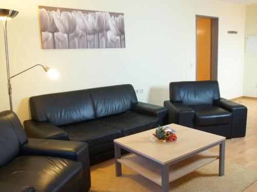 a living room with a couch and two chairs and a table at Atlanta Boardinghouse Leipzig in Leipzig