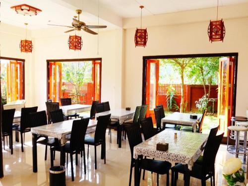 a restaurant with tables and chairs and windows at Donut Resort in Ban Dong