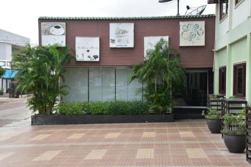 a building with palm trees in front of it at Hungheuang Hotel in Savannakhet