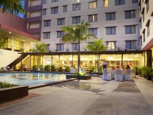 a hotel with a swimming pool and a building at Asialink Premier in Karawang