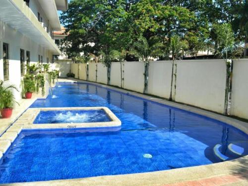 a swimming pool with blue water in a building at Subic Bay Venezia in Olongapo