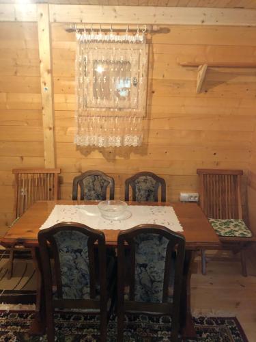 a dining room with a wooden table and chairs at Prokletije Vucetic sobe in Dolja