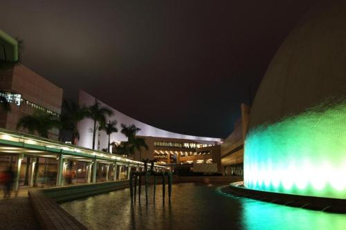 a lit up building with a fountain in front of it at night at Harbour Bay Hotel in Hong Kong