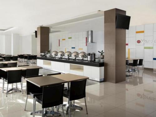 a kitchen with tables and chairs in a room at Amaris Hotel Kupang in Klapalima