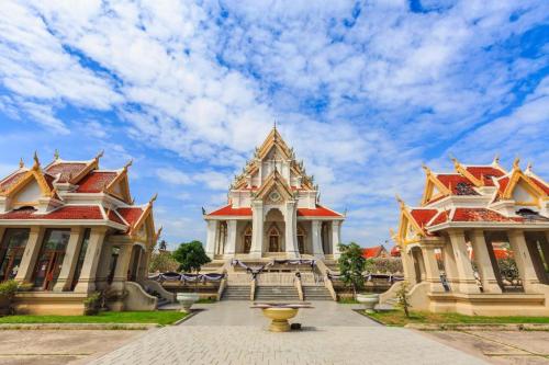 a building with a fountain in front of two buildings at Palm Sweet Hotel in Prachuap Khiri Khan