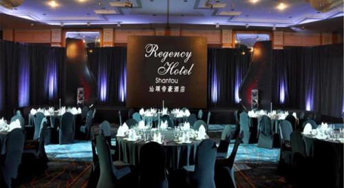 a banquet hall with tables and chairs and a sign at Regency Hotel in Shantou