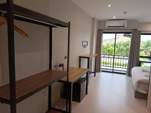 a room with a bed and a desk and a bedroom at The Way Hotel Ban Pong in Ban Pak Raet