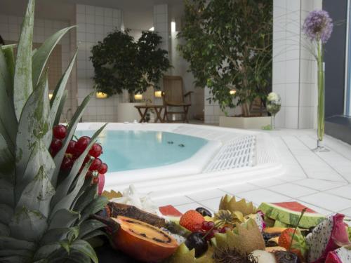 a pool with fruits and vegetables next to a table at Atlanta Boardinghouse Leipzig in Leipzig
