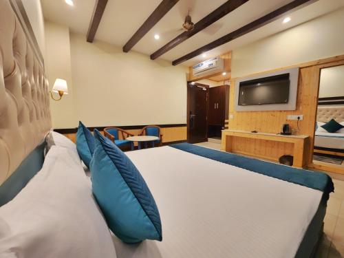 a hotel room with a large bed and a flat screen tv at Wonder Hill Kasauli in Kasauli