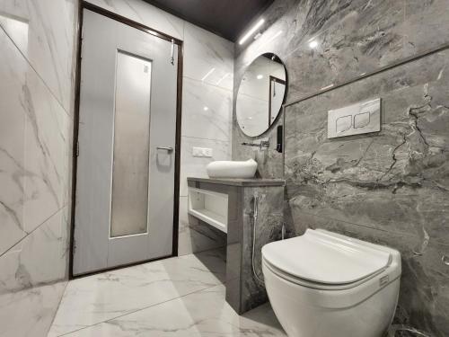 a bathroom with a toilet and a sink and a mirror at Wonder Hill Kasauli in Kasauli