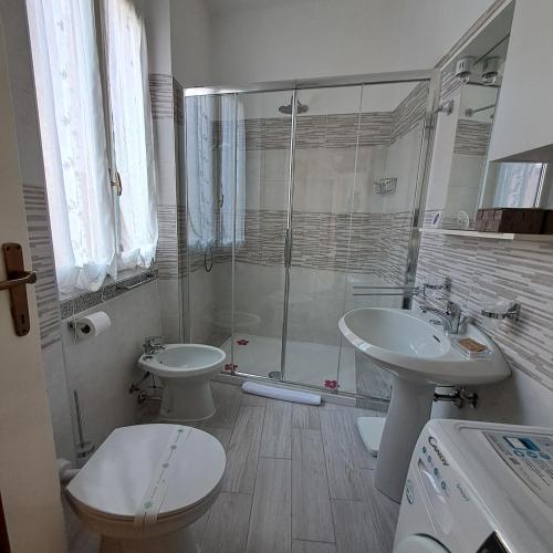 a bathroom with a shower and two sinks and a toilet at Da Vinci Refuge 2 in Limonta