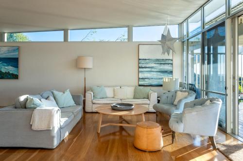 a living room with two couches and a table at Percy Street I Private Properties in Gracetown