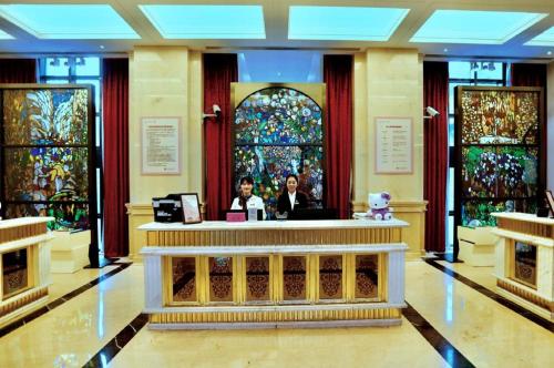 two people sitting at a counter in a lobby at Yin Run Jin Jiang Castle Hotel in Huzhou