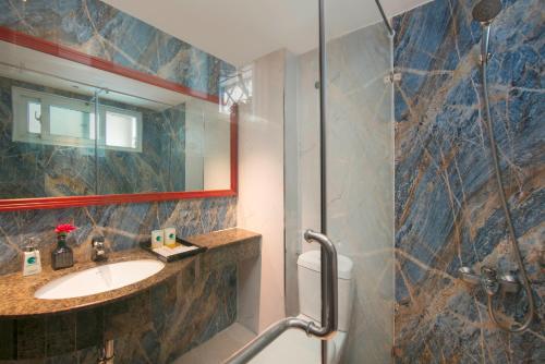a bathroom with a sink and a shower at Hanoi Center Silk Classic Hotel & Travel in Hanoi