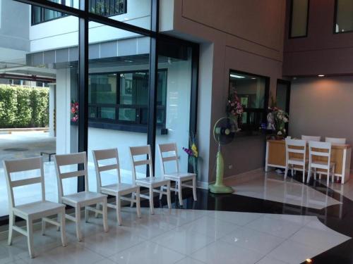 a group of chairs and a table in a building at Ipremium Sukhumvit 81 Hotel in Bangkok