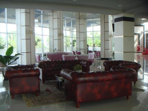 a lobby with leather couches and tables and windows at CK Tanjungpinang Hotel and Convention Centre in Tanjung Pinang 