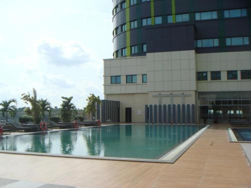 a building with a swimming pool in front of a building at CK Tanjungpinang Hotel and Convention Centre in Tanjung Pinang 