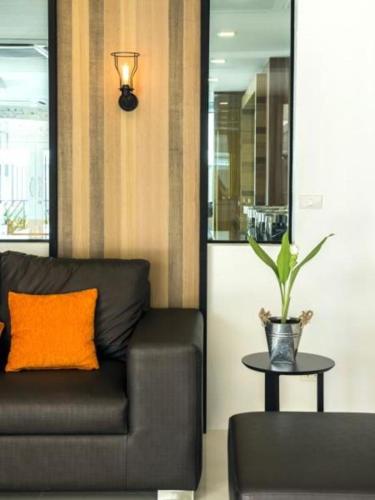 a living room with a couch and a potted plant at The Circle Hotel in Buriram
