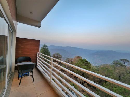 a balcony with a chair and a view of the mountains at Wonder Hill Kasauli in Kasauli