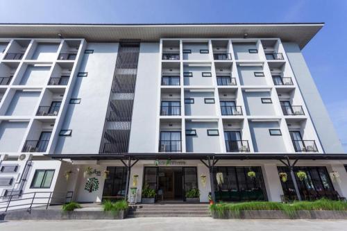 an exterior view of a white building at Le Park Hotel in Nakhon Si Thammarat