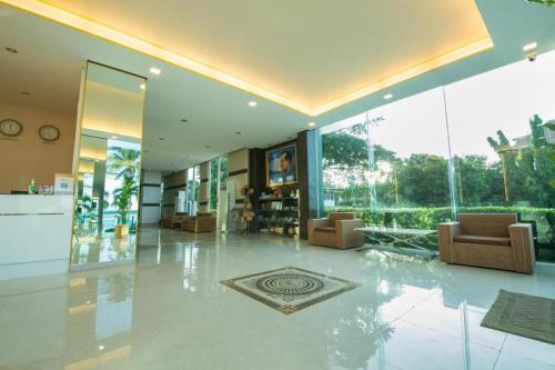 a large room with a lobby with chairs and windows at Phuglong Hotel in Phayao