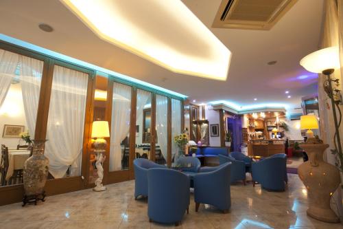 eine Hotellobby mit blauen Stühlen und Tischen und ein Zimmer in der Unterkunft Hotel Medusa in Sottomarina