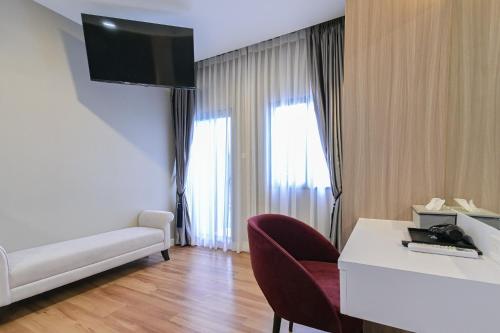 a room with a couch and a table and a television at Shewin de Bangkok in Ban Bang Bamru