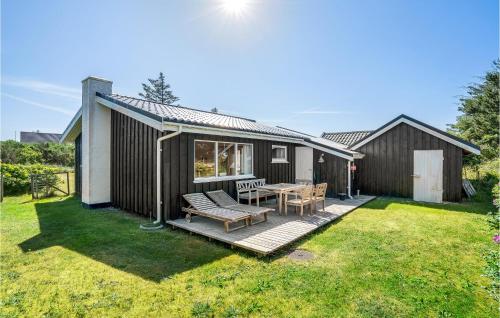 a house with a deck with a table and chairs at Holiday Home Lyngvej Blokhus Iv in Blokhus