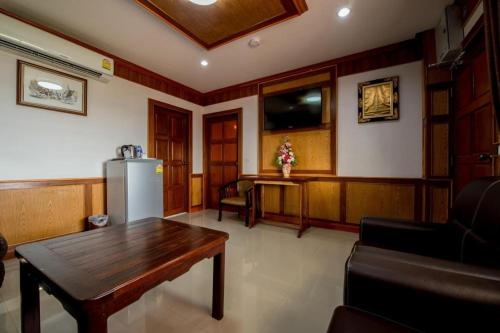 a living room with a table and a refrigerator at Thatphanom View Hotel Nakhon in Nakhon Phanom