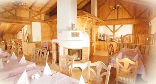 a dining room with tables and chairs and a fireplace at Gasthof & Hotel Jägerwirt in Aufhofen