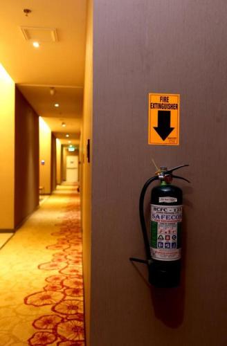 a fire extinguisher sign on a wall in a hallway at Lotus Blu Hotel in Legazpi