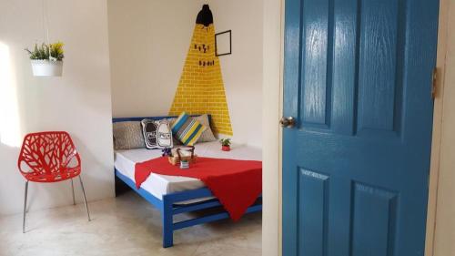 ein Zimmer mit einem Bett und einem Tisch mit einem Gebäude an der Wand in der Unterkunft The Sugar Hostel in Ban Sai Ma