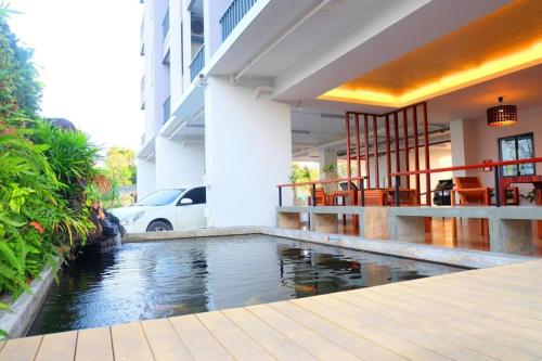 a house with a swimming pool in front of a house at The Pride in Nakhon Pathom