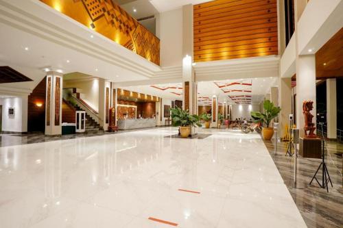 a lobby with a large white floor and a building at Hotel Niagara Parapat in Parapat