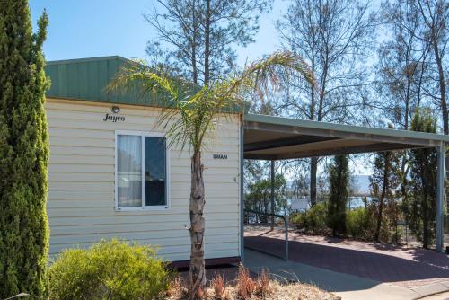a small white house with a tree in front of it at Echo Holiday Parks - Port Pirie in Port Pirie