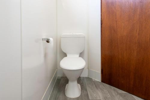 a bathroom with a toilet and a wooden door at Echo Holiday Parks - Port Pirie in Port Pirie