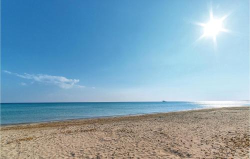 a beach with the sun shining over the ocean at Nocellara in Alia