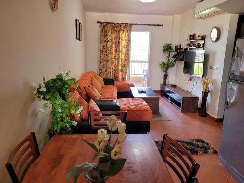 ein Wohnzimmer mit Tisch und Couch in der Unterkunft بورتو الجولف in El-Alamein