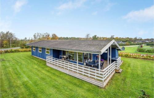 a blue house with a porch on a grass field at Holiday Home Egernsund With A Fireplace 320 in Egernsund