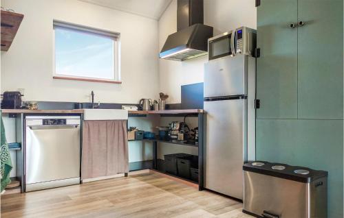 una cocina con frigorífico y fregadero en Huisje 4, en Grashoek