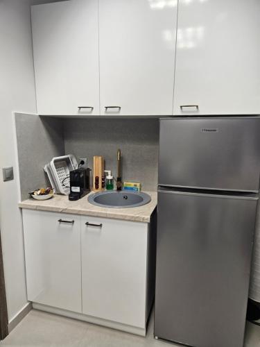 a kitchen with a sink and a refrigerator at DATA Maisonettes and more in Chios