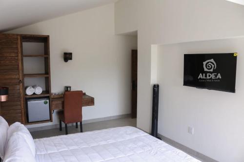 a bedroom with a bed and a table and a kitchen at ALDEA Luxury villas & suites in San Martín de las Pirámides