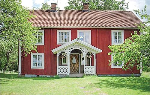 a red house with a door in a yard at Four-Bedroom Holiday Home In Virserum in Bockasjögle