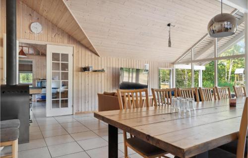a dining room with a wooden table and chairs at Lovely Home In Rødby With Kitchen in Rødby